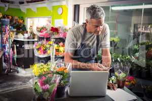 Male florist using mobile phone