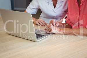 Nurse and senior woman using a laptop
