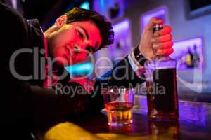 Drunken man leaning on bar counter