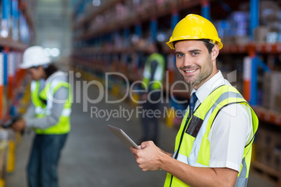 Worker in warehouse looking at camera