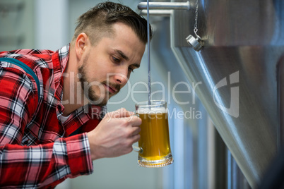 Close-up of brewer testing beer