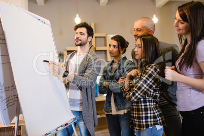 Team of graphic designer discussing chart on white board