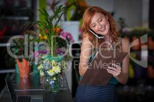 Female florist taking order on mobile phone
