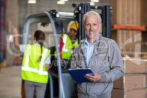 Portrait of worker holding a clipboard and looking the camera