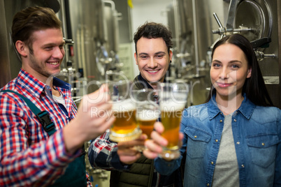 Brewers toasting beers at brewery factory