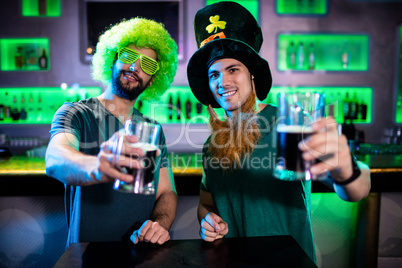 Male friends holding beer mugs