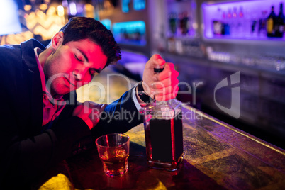 Drunken man leaning on bar counter