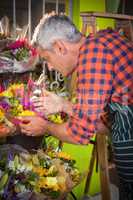Male florist arranging bouquet of flower at flower shop
