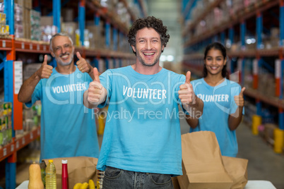 Portrait of happy volunteers are posing with thumbs up