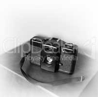 Black and white vintage camera with strap vignette bokeh backgro
