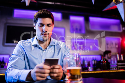 Man using mobile phone at bar counter