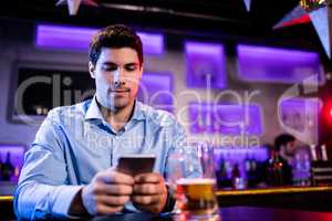 Man using mobile phone at bar counter