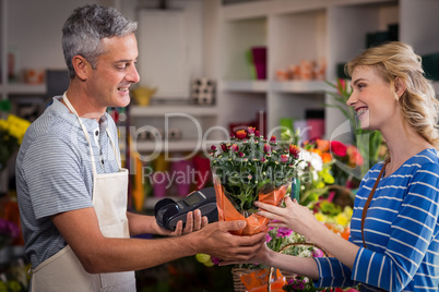 Florist giving bouquet of flower to woman