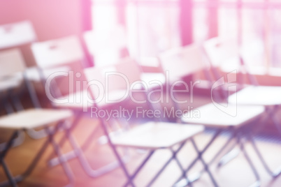 Classroom with empty chairs and pink bokeh background