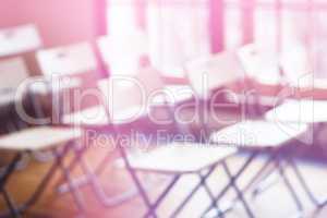 Classroom with empty chairs and pink bokeh background