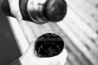 Filling cup with hot tea from thermos bokeh background