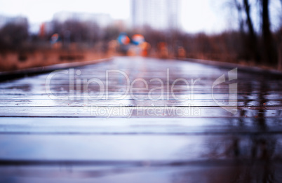 Wooden wet path in park bokeh background