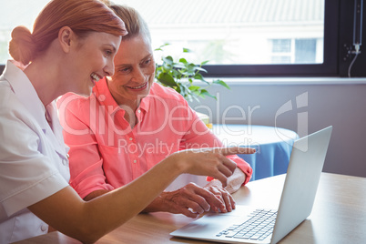 Nurse and senior woman using a laptop