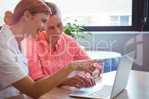 Nurse and senior woman using a laptop