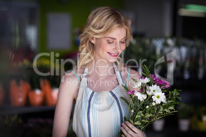 Female florist holding bunch of flower in flowers shop