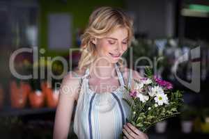 Female florist holding bunch of flower in flowers shop