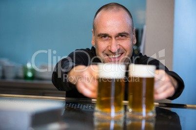 Portrait of bar tender offering beer