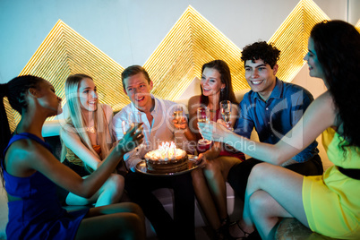 Group of smiling friends having a glass of champagne while celeb