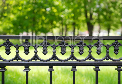 Horizontal park fence with green bokeh background