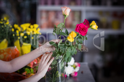 Female florist arranging flower bouquet in vase