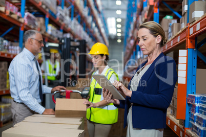 Business woman standing in front warehouse worker in warehouse