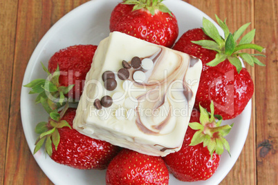 ripe red strawberries on the white plate and cake