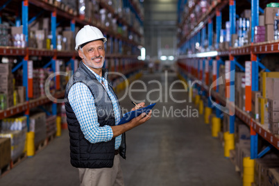 Happy manager holding a clipboard and posing during work