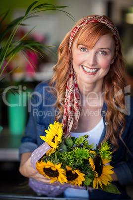 Smiling female florist holding bunch of flower