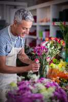 Smiling florist preparing a flower bouquet