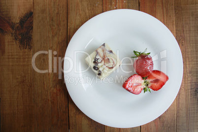 cut strawberries on the white plate and cake