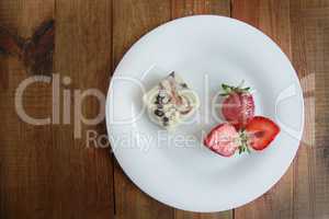 cut strawberries on the white plate and cake