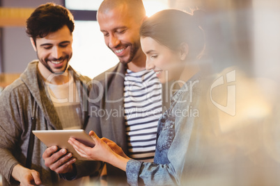 Graphic designer using digital tablet with his coworker