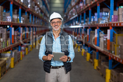 Portrait of happy worker is holding a tablet and posing