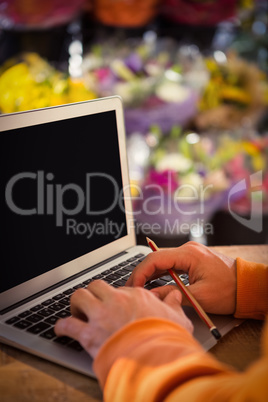 Male florist working on laptop