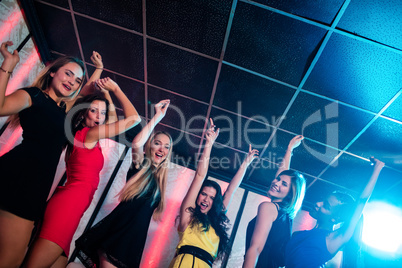 Smiling friends dancing on dance floor