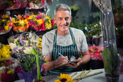 Male florist writing on clipboard