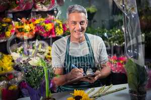 Male florist writing on clipboard