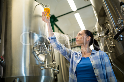 Female brewer testing beer