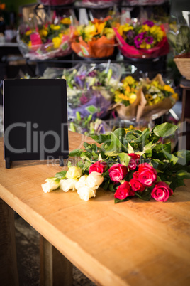 Bunch of roses and digital tablet on the wooden table