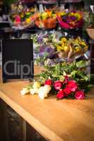 Bunch of roses and digital tablet on the wooden table