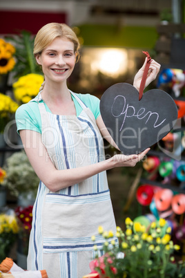 Female florist holding open signboard