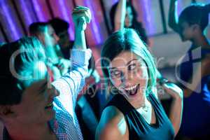 Smiling friends dancing on dance floor