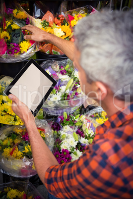 Male florist checking order on digital tablet