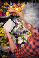 Male florist checking order on digital tablet