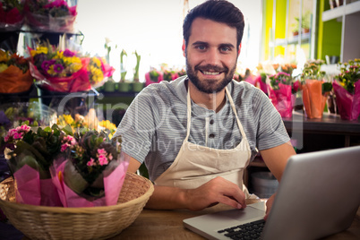 Male florist using laptop at his flower shop